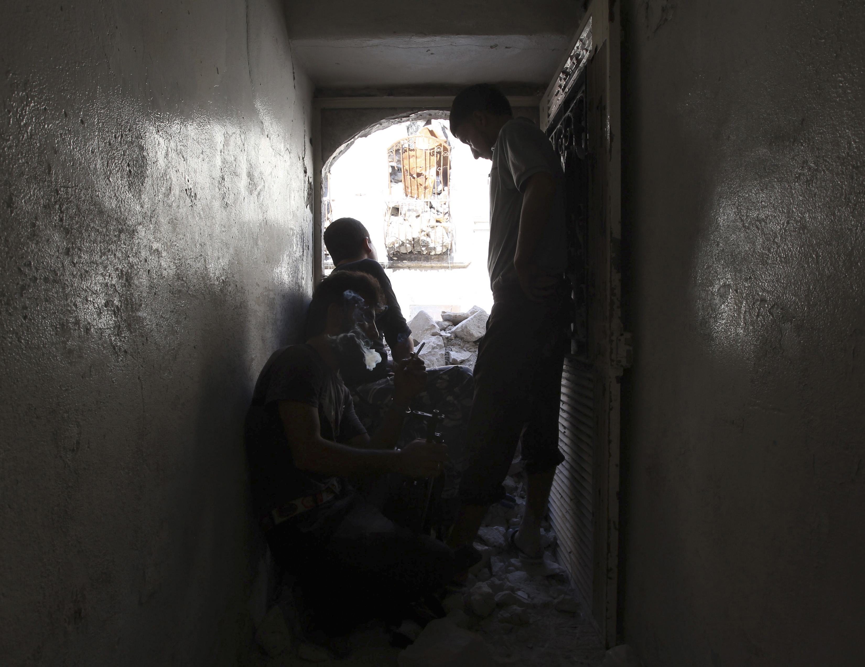 A Free Syrian Army fighter calls out to Syrian regime troops to defect in the old city of Aleppo