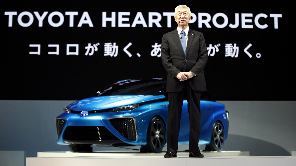 Toyota Motor Corp’s Executive Vice President Kato speaks in front of the company’s fuel cell vehicle concept car at the 43rd Tokyo Motor Show