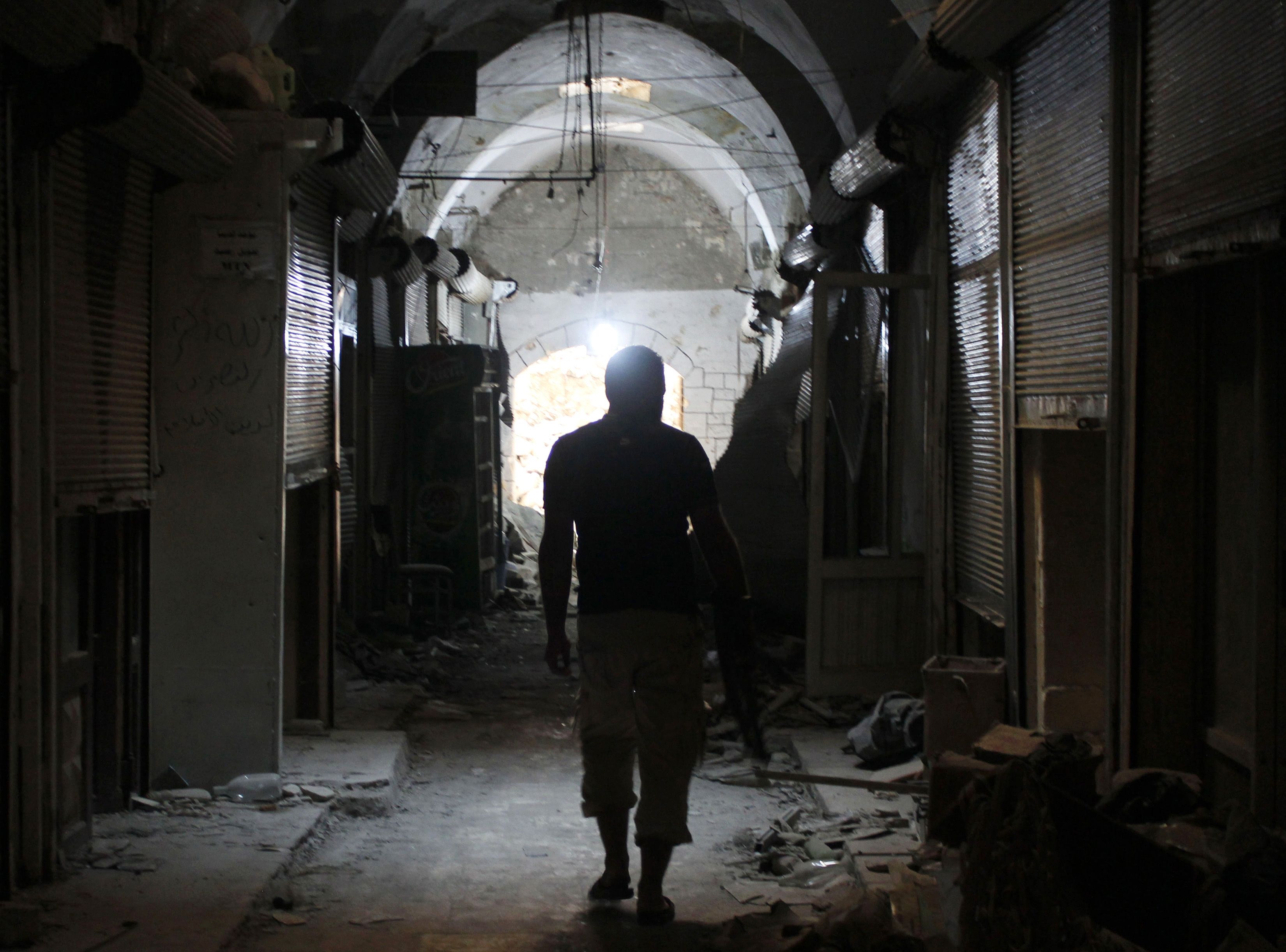 A Free Syrian Army fighter holds his weapon as he heads to the entrance of the Grand Umayyad mosque in Aleppo